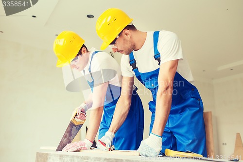 Image of group of builders with tools indoors