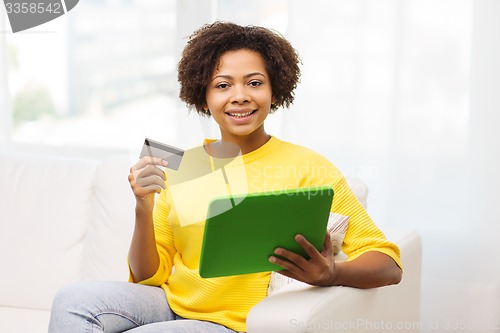 Image of happy african woman with tablet pc and credit card