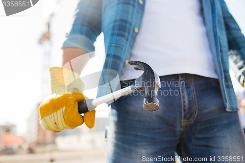 Image of close up of builder hand in glove holding hammer