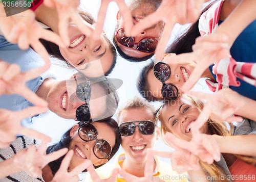 Image of smiling friends in circle on summer beach