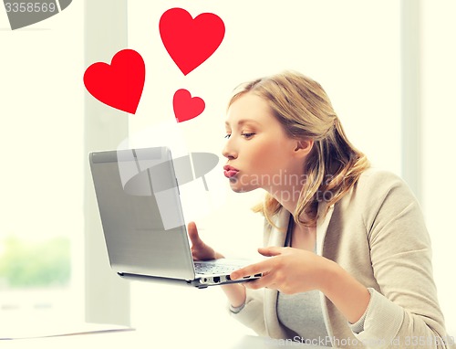 Image of woman sending kisses with laptop computer