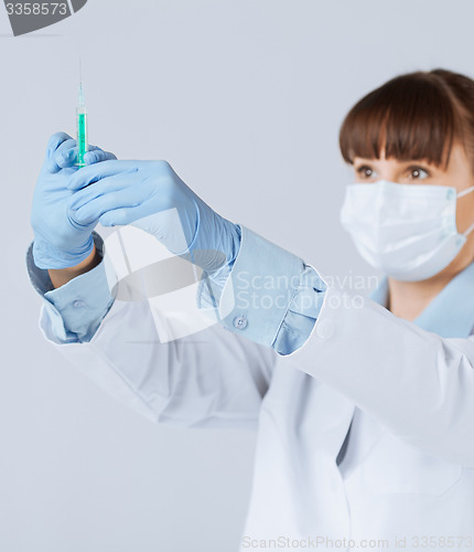 Image of female doctor holding syringe with injection