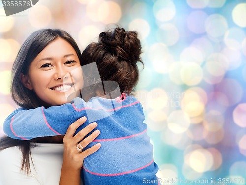 Image of happy mother and daughter hugging