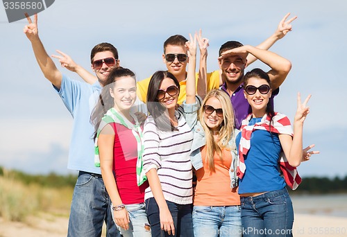 Image of group of happy friends having fun on beach