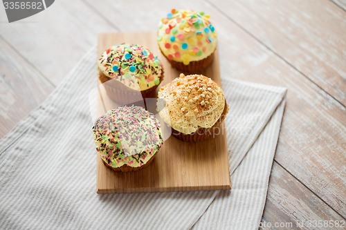 Image of close up of glazed cupcakes or muffins on table