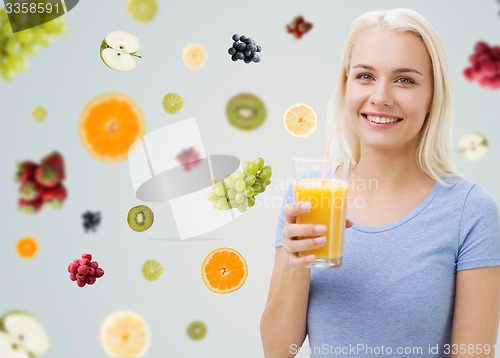 Image of smiling woman drinking orange juice at home