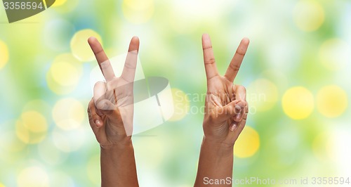 Image of two african hands showing victory or peace sign