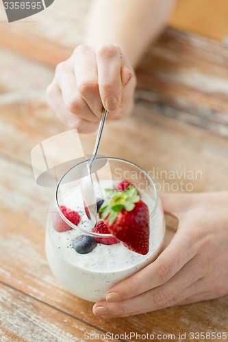 Image of close up of woman hands with yogurt and berries