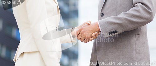 Image of close up of business couple shaking hands