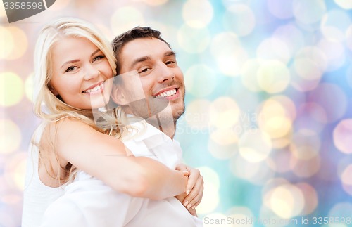 Image of happy couple hugging over holidays lights 