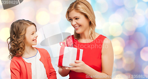 Image of smiling mother and daughter with gift box