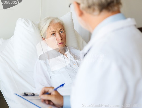 Image of senior woman and doctor with clipboard at hospital