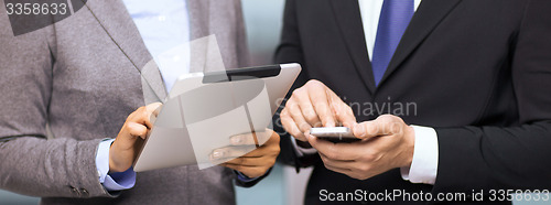 Image of two businesspeople with smartphone and tablet pc