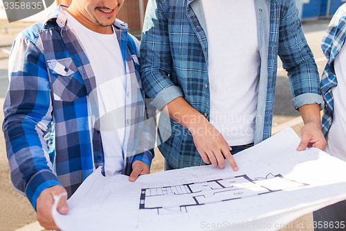 Image of close up of smiling builders with blueprint