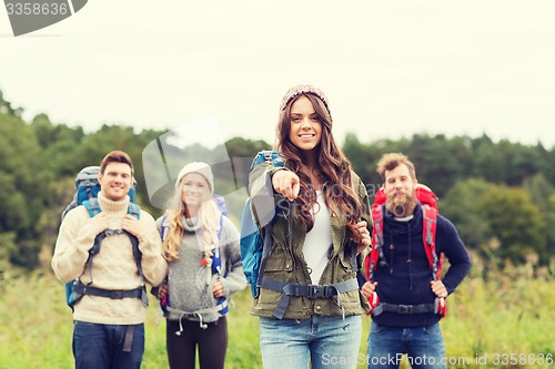 Image of smiling hikers with backpacks pointing finger