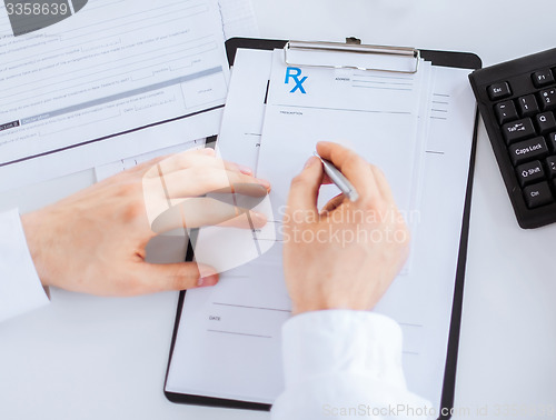 Image of male doctor writing prescription paper