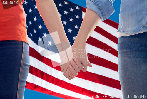 Image of close up of lesbian couple holding hands