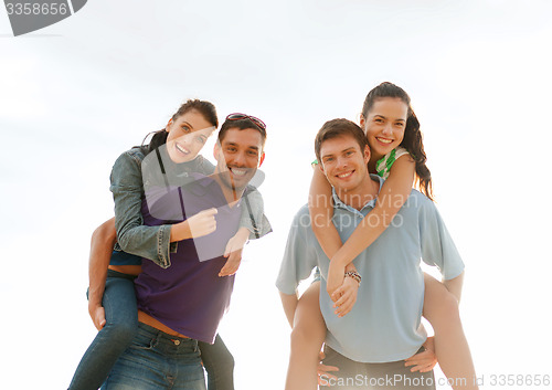 Image of group of happy friends having fun outdoors