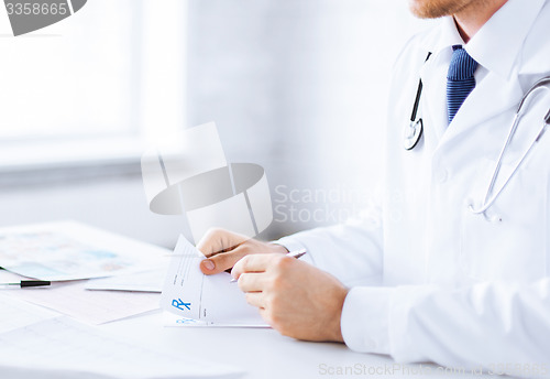 Image of male doctor writing prescription paper