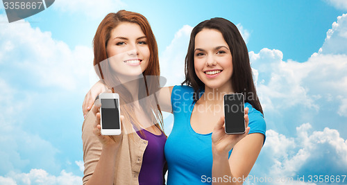 Image of happy young women showing smartphones screens