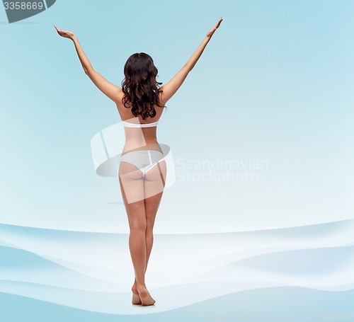 Image of young woman in white bikini swimsuit from back