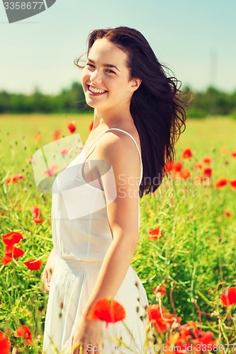 Image of smiling young woman on poppy field