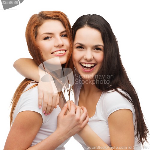 Image of two laughing girls in white t-shirts hugging