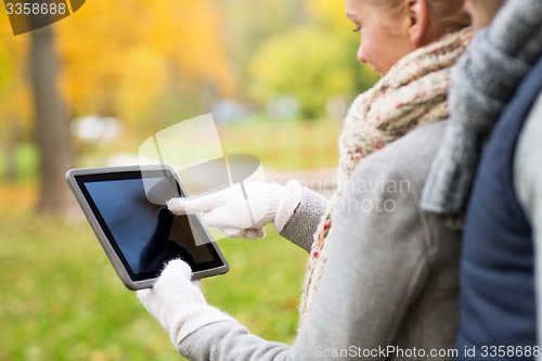 Image of couple hands in gloves with tablet pc outdoors