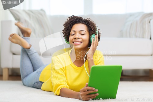 Image of happy african woman with tablet pc and headphones