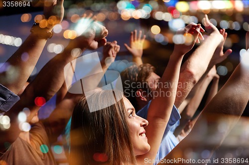 Image of smiling friends at concert in club