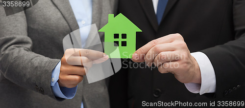 Image of businessman and businesswoman holding green house