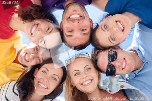 Image of smiling friends in circle on summer beach