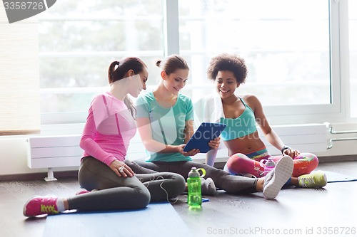 Image of group of happy women with tablet pc in gym