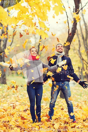 Image of smiling couple having fun in autumn park