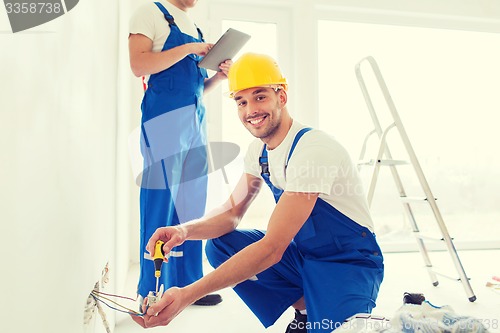 Image of builders with tablet pc and equipment indoors