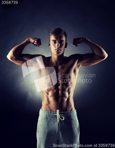 Image of young man showing biceps