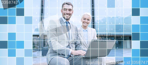 Image of smiling businesspeople with laptop outdoors