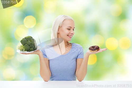 Image of smiling woman with broccoli and donut