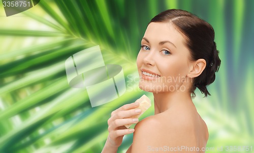 Image of woman with soap over green palm leaf background