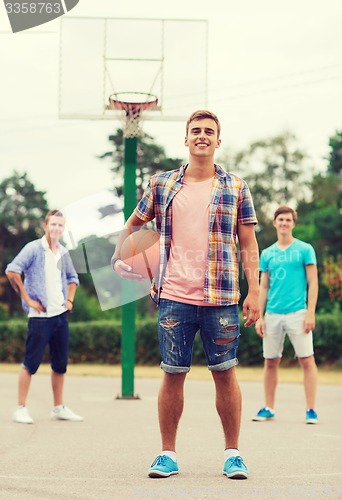 Image of group of smiling teenagers playing basketball