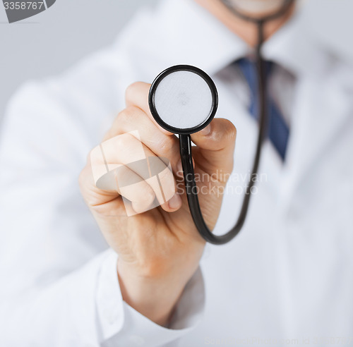 Image of doctor hand with stethoscope listening something