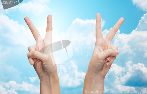 Image of woman hands showing victory or peace sign