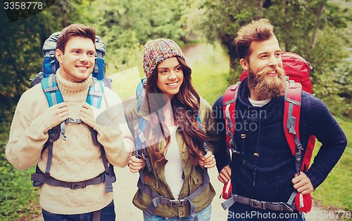 Image of group of smiling friends with backpacks hiking