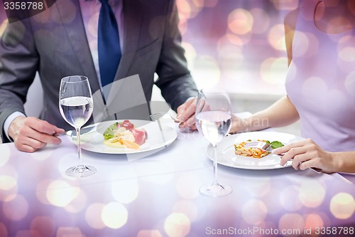 Image of close up of couple eating appetizers at restaurant