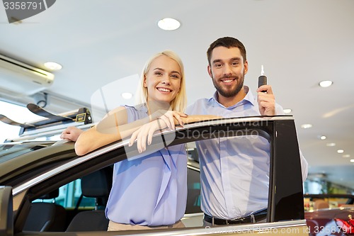 Image of happy couple buying car in auto show or salon