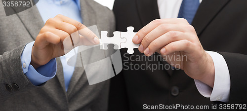 Image of businessman and businesswoman with puzzle pieces