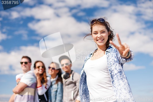 Image of teenage girl with headphones and friends outside