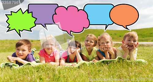 Image of group of kids lying on blanket or cover outdoors