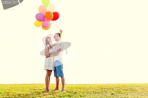 Image of smiling couple with air balloons outdoors