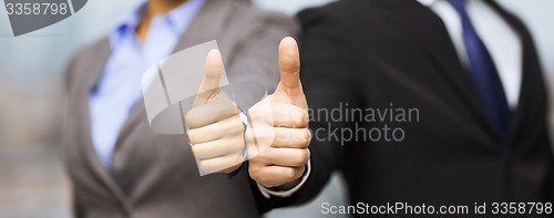 Image of businessman and businesswoman showing thumbs up